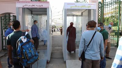 Egyptian People walk through a sanitising gate at Cairo university after a repatriation flight from Kuwait in Giza, Egypt EPA