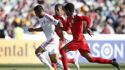 UAE's Ali Mabkhout, left, is challenged by Bahrain's Mohamed Hassan, centre, and Bahrain's Mohamed Duaij during their Asian Cup match at the Canberra Stadium on Thursday. REUTERS/Tim Wimborne