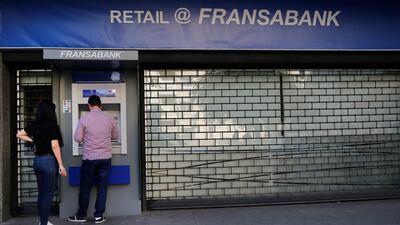People use ATM outside a closed bank, in Beirut. Lebanese banks have been closed for the last two weeks as the government grapples with mass demonstrations that have paralyzed the country, but an even greater crisis may set in when they reopen Friday. AP
