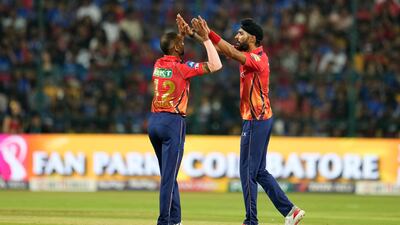 Punjab Kings' Harpreet Brar, right, celebrates with captain Shikhar Dhawan after the dismissal of Royal Challengers Bengaluru's Rajat Patidar for 18. AP