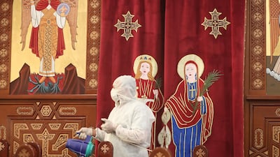 A member of a medical team sprays disinfectant at a church in Cairo. EPA
