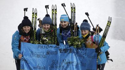 Gold medalists Vita Semerenko, Juliya Dzhyma, Olena Pidhrushna and Valj Semerenko of Ukraine celebrate after the flower ceremony for the women's biathlon 4x6km relay at the Sochi 2014 Winter Olympics on February 21, 2014. Adam Pretty / Getty Images
