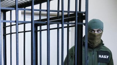 A member of the National Anti-Corruption Bureau of Ukraine stands guard next to a defendants' cage in Kiev, Ukraine. Valentyn Ogirenko/Reuters