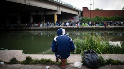 A migrant sits by the canal as he awaits the evacuation of a large makeshift camp along the Canal Saint Denis, in northern Paris, France, 30 May 2018. Ian Langsdon / EPA