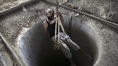 A Palestinian man lowered into a smuggling tunnel which connects the Gaza Strip and Egypt in Rafah, southern Gaza Strip on 10 September 2013. Ali Ali/EPA