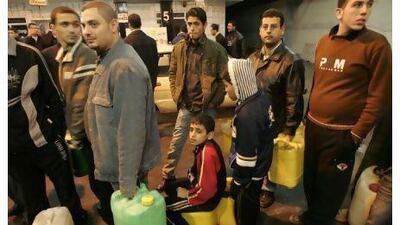 Palestinians wait to fill petrol in containers at a petrol station in Gaza.