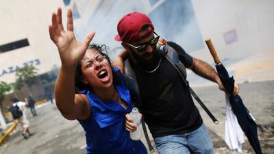 A woman hurt by tear gas is pulled away during a May Day protest in San Juan, Puerto Rico. Alvin Baez / Reuters