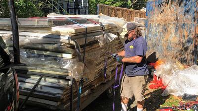 George Martin secures to a trailer paintings by Francis Hines that were found in a dumpster. AP