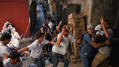 Israeli journalist Nir Hasson comes to the aid of Mr Al Qawasmi as he is attacked by young right-wing marchers in occupied Jerusalem. Photo: Maya Levin / X