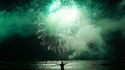 A man celebrates the start of the New Year watching fireworks explode over Santos Bay in Brazil. AP Photo