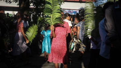 People hold fronds before Palm Sunday Mass, commemorating Jesus Christ’s entry into Jerusalem, at Balide Church in Dili, East Timor. AFP