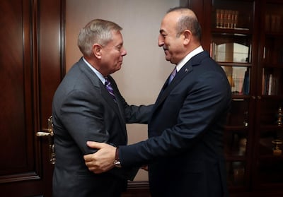 Turkey's Foreign Minister Mevlut Cavusoglu, right, and US Republican senator Lindsey Graham discussing the US withdrawal from Syria last week.Turkish Foreign Ministry Press Service via AP / pool