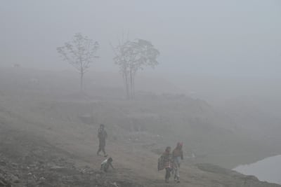 Children walk a path engulfed in smog in Lahore on Wednesday after air pollution hit record levels this month. AFP