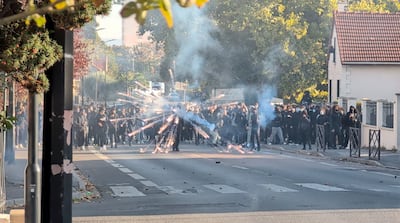 A protester launches a firework during clashes with police in Sartrouville, near Paris. Reuters