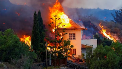 A house catches fire in La Palma as lava flows from the eruption. Photo: Reuters