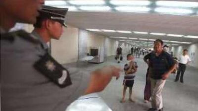 Chinese security personnel single out passersby for a security check near Tiananmen Square in Beijing.