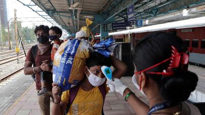 A health worker checks the body temperature of a traveller at a train station in Mumbai, India. AP Photo