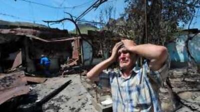 An ethnic Uzbek despairs as he stands beside the wreckage of his burnt home in Osh yesterday. Deadly gun battles raged in the city, where bodies littered the streets as ethnic violence escalated and Uzbekistan raced to cope with a refugee influx.