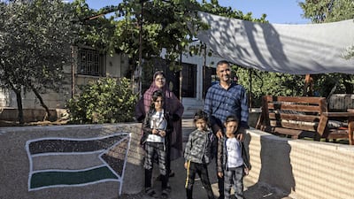 Mr Gharib poses with members of his family in front of his house.