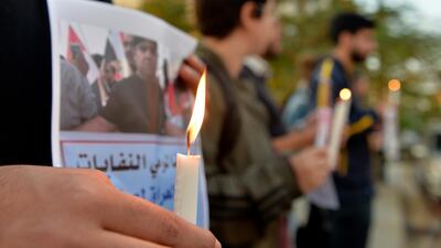 Lebanese activists hold candles during a protest to support children taking part in the uprising in front of the Iraqi embassy in Beirut. EPA
