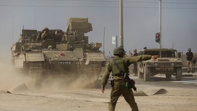 A soldier gives directions to a tank unit near the border with Gaza on Saturday near Sderot, Israel. Getty