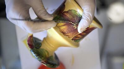 Aayeda al Zaharna decorating a clay incense burner at her home in Abu Dhabi. Silvia Razgova / The National