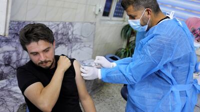 An Iraqi man receives a dose of the Pfizer-BioNTech vaccine in Baghdad. EPA