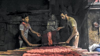 Adham, Egypt: This photo shows two brothers working in their family’s century-old business of weaving colored cotton in the Darb El Ahmar souq in Cairo