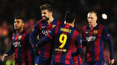 Gerard Pique of Barcelona celebrates victory with Luis Suarez in the Champions League last-16 match on Wednesday. David Ramos / Getty Images