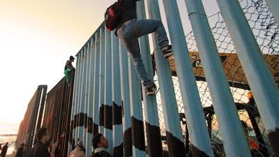 Migrants from a caravan of Central Americans mainly from Honduras congregate on the border fence in Tijuana, Mexico. EPA