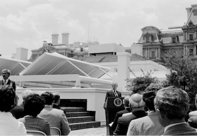 US president Jimmy Carter stands in front of the newly installed solar panels on the roof of the White House in 1979. National Archives