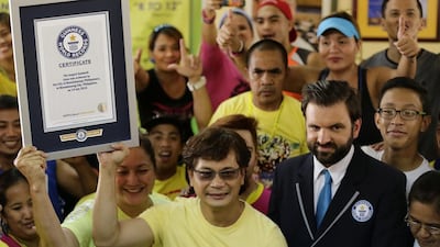 Filipino Mandaluyong city mayor Benhur Abalos, centre, displays the Guinness World Record for having the largest Zumba class certificate next to Guinness adjudicator official Allan Pixley, right, in Mandaluyong city, eastern Manila, Philippines. Francis R Malasig / EPA
