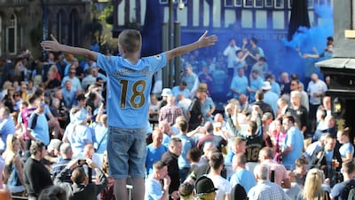 Manchester City fans cheer during the team's bus parade to celebrate their English Premier League title win, in Manchester. Nigel Roddis / EPA