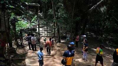 Visitors taking photos near the entrance of the Tham Luang cave. AFP