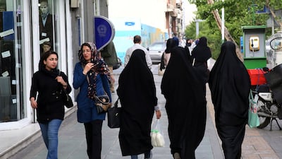 Iranian women walk along a pavement in downtown Tehran. Iran's morality police have announced a new campaign to force women to wear the Islamic headscarf. AP