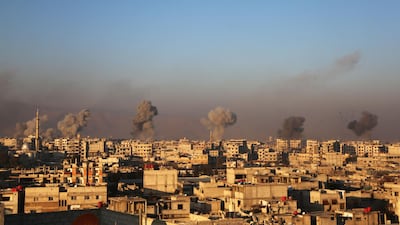 Smoke rises from buildings following air strikes on the rebel-held besieged town of Arbin, in the eastern Ghouta region on the outskirts of the capital Damascus. Amer Almohibany / AFP