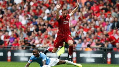 Liverpool's Jordan Henderson hurdles Manchester City's Raheem Sterling. AFP