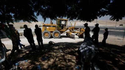 Palestinians watch as an Israeli bulldozer works in the West Bank hamlet of Khan al-Ahmar. AP Photo/Majdi Mohammed