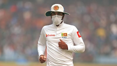 Sri Lanka's captain Dinesh Chandimal fields wearing an anti-pollution mask during the second day of their third test cricket match against India in New Delhi. Altaf Qadri / AP Photo