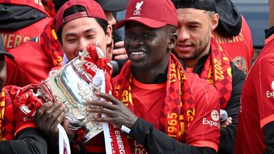 Liverpool's Senegalese striker Sadio Mane celebrates with temmates on an open-top bus during a parade through the streets of Liverpool in north-west England on May 29, 2022, to celebrate winning the 2021-22 League Cup and FA Cup. - Despite the disappointment of losing to real Madrid in the final of the UEAF Champions League, Klopp has called on Liverpool fans to take to the streets of the city on Sunday when they parade the League Cup and FA Cup. (Photo by Oli SCARFF / AFP)