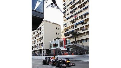 Mark Webber takes the chequered flag as he crosses the finish line in Monte Carlo yesterday.