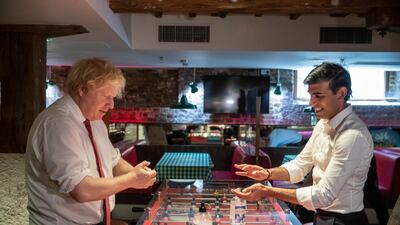 British Prime Minister Boris Johnson and Mr. Sunak consider a game of table football. Getty Images