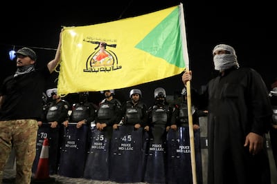 Iraqi security personnel watch protesters gather outside the Kuwaiti consulate in Basra in April. Reuters