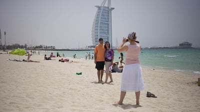 Tourists from Turkey taking pictures at the public beach by Burj Al Arab. Razan Alzayani / The National
