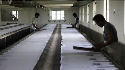 Workers perform a manual printing process at Prime Tech Knit Prints in Tirupur, India. India's export industries like garment manufacturing are losing orders to China and Bangladesh.