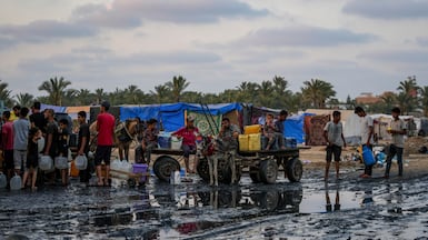 Palestinians fill water jugs near one of Gaza's few functioning desalination plants in Deir Al Balah. AP