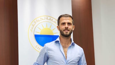 Miralem Pjanic poses with a Sharjah FC shirt after completing his move to the UAE club. Photo: Sharjah FC