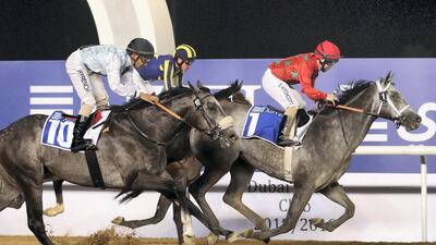 Al Seel Legacy, in grey, ridden by Sam Hitchcott, wins the Azizi Star at Meydan Racecourse in Dubai on Thursday night.
