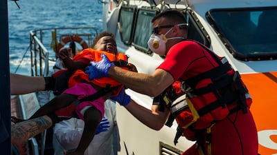 Maltese Armed Forces help a child to board their ship from the German humanitarian vessel Alan Kurdi on Sunday. AP
