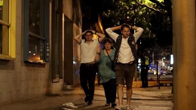 People with their hands on their heads about 10 minutes after midnight as they leave from inside a police cordon after the attack in London. Matt Dunham / AP Photo